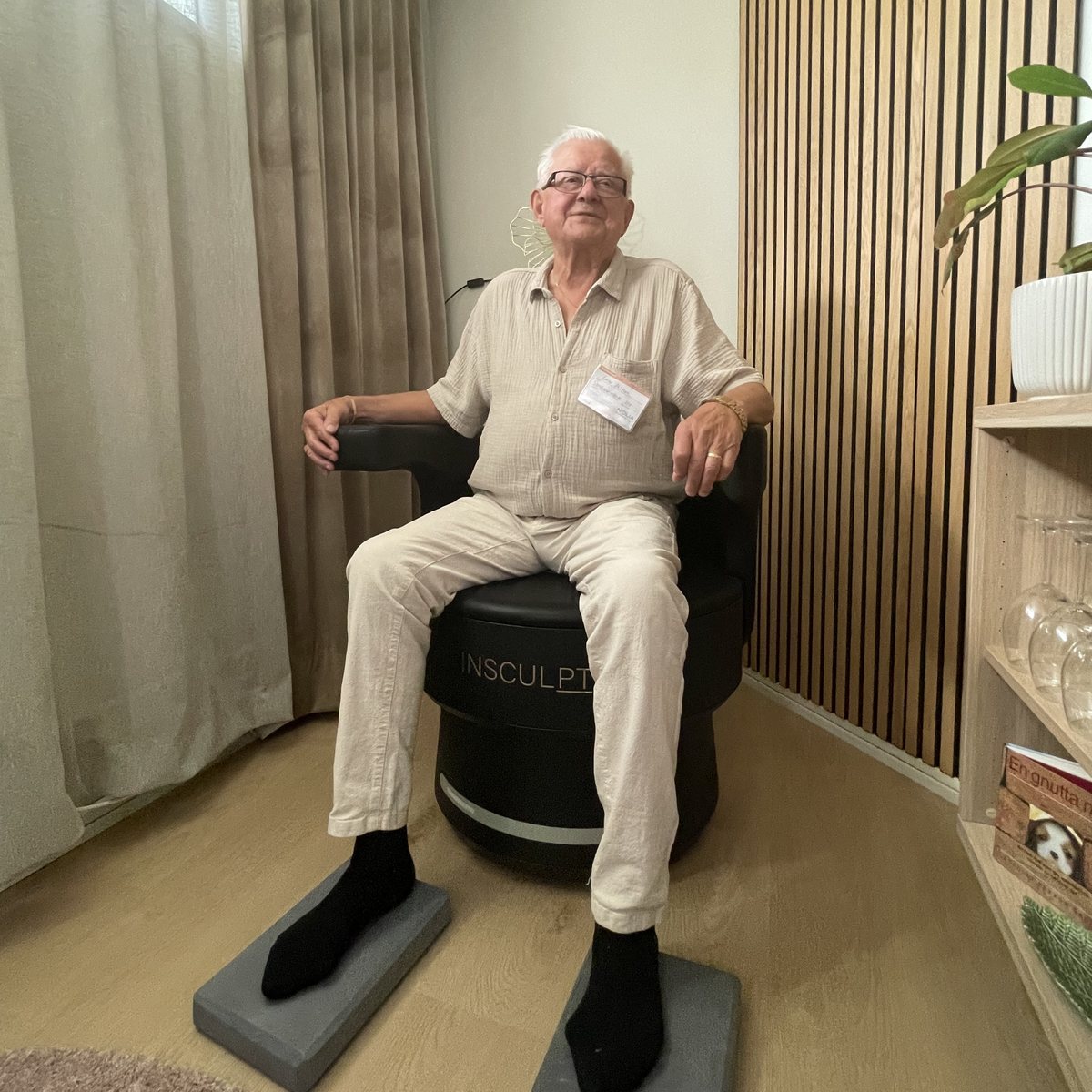 En kund sitter fullt påklädd i Insculpt Chair i behandlingsrummet hos BodyRecovery i Piteå